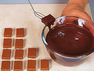 Обережно занурте вилку в розтоплений і темперований шоколад і вийміть, потримавши кілька секунд над шоколадом, щоб його надлишок стек в миску
